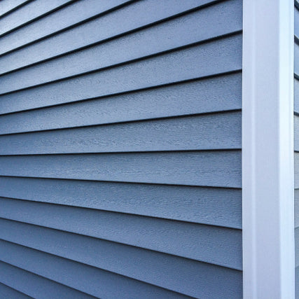 SidingGray vinyl siding on a house corner. Horizontal panels create a clean, modern look. The tone is calm, structured, and contemporary.
